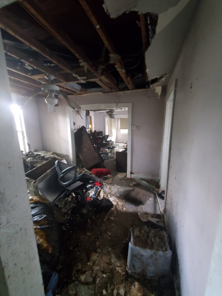 Interior fire damage with collapsed ceiling and exposed joists — insurance restoration project