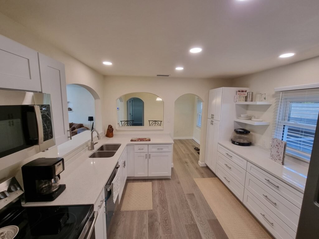 Updated kitchen with white cabinetry, granite counters, and stainless steel appliances